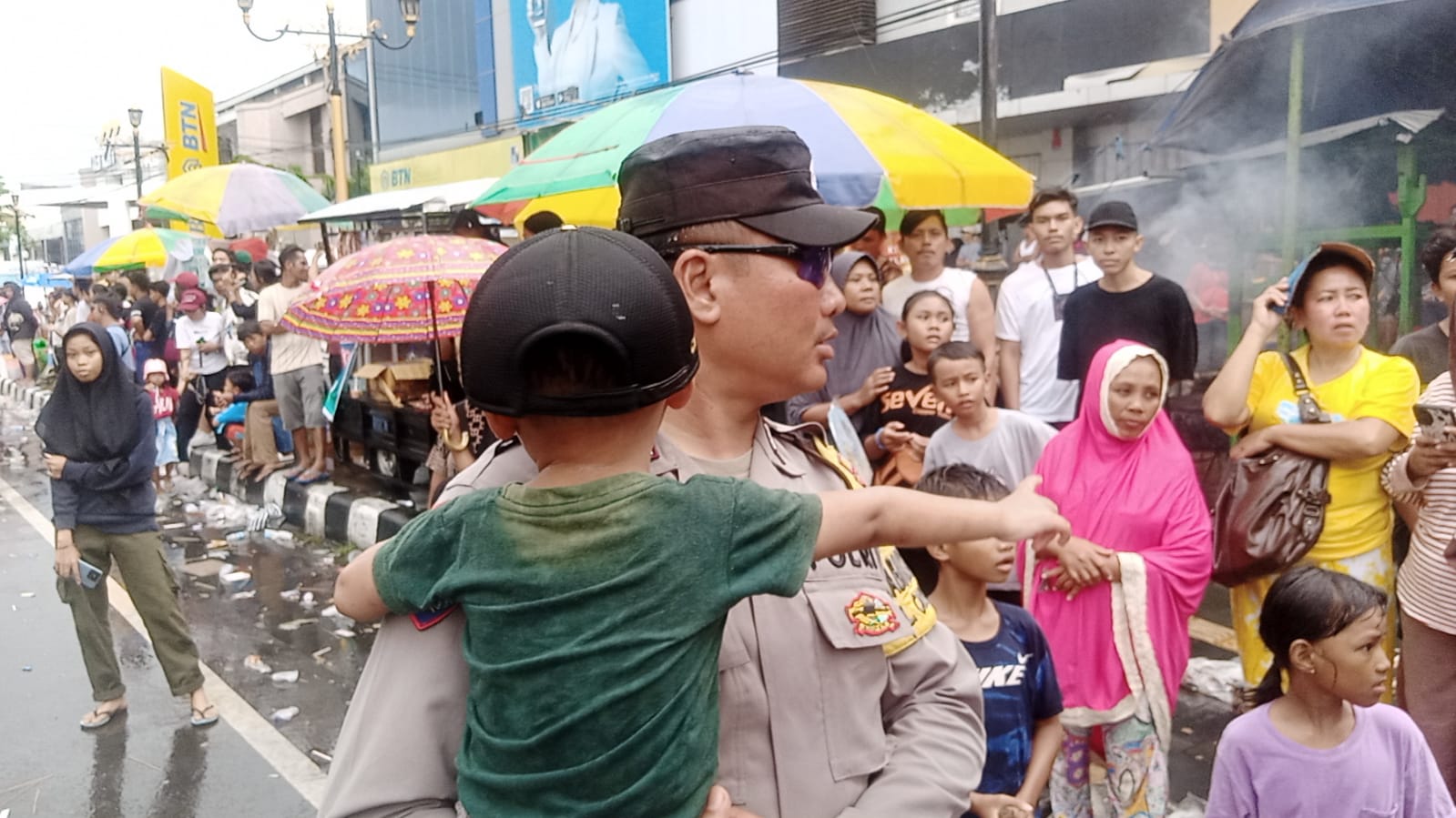 DISELAMATKAN: Seorang balita yang terpisah dari orang tuanya saat Pawai Ogoh-Ogoh di Kota Mataram diselamatkan petugas Polsek Sandubaya Bripka Ida Bagus Sutha, Minggu (10/3).