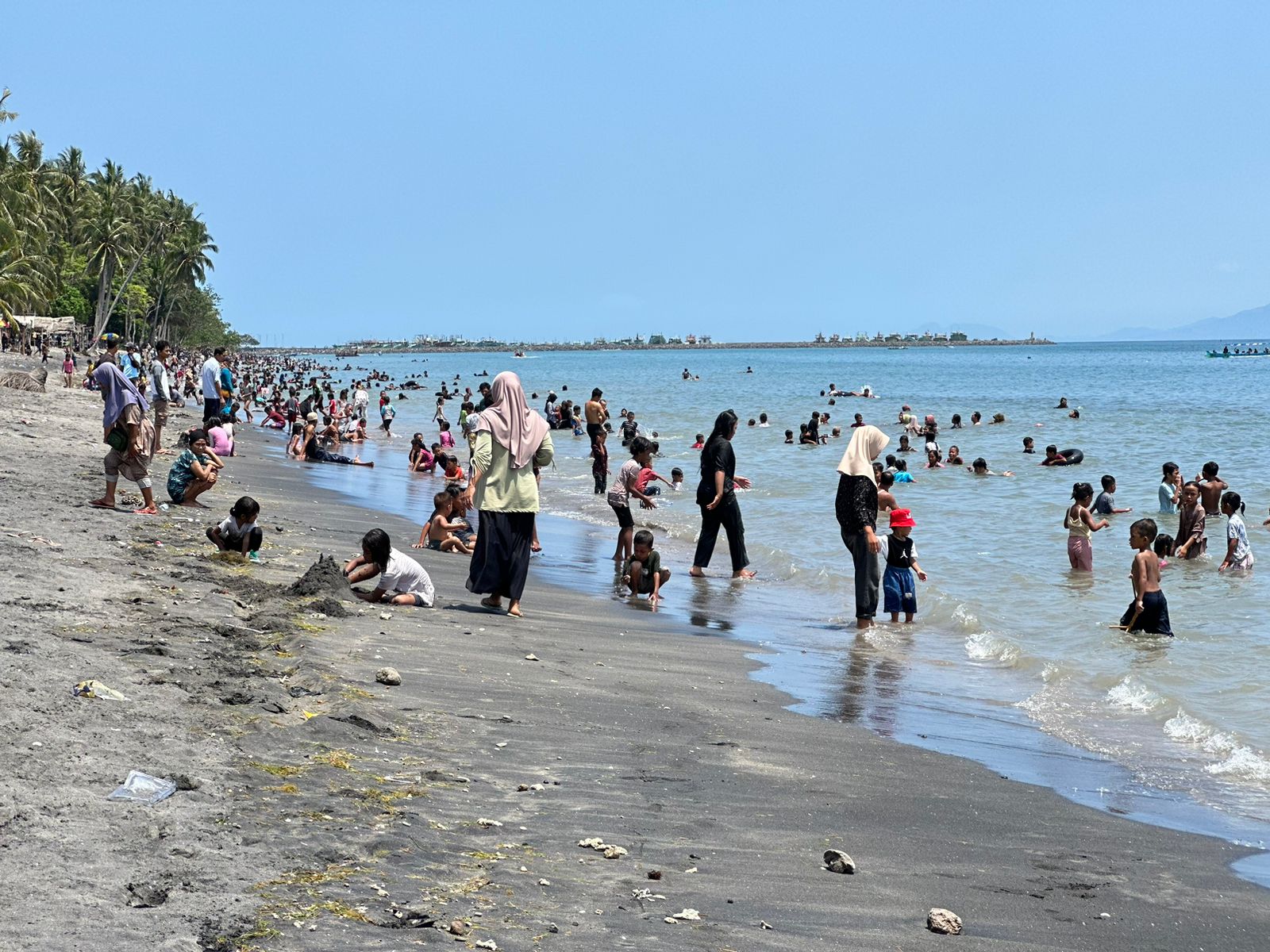 MANDI: Pengunjung di pantai Sunrise Land Lombok bermain air saat momentum bersin puasa, Minggu (10/3).