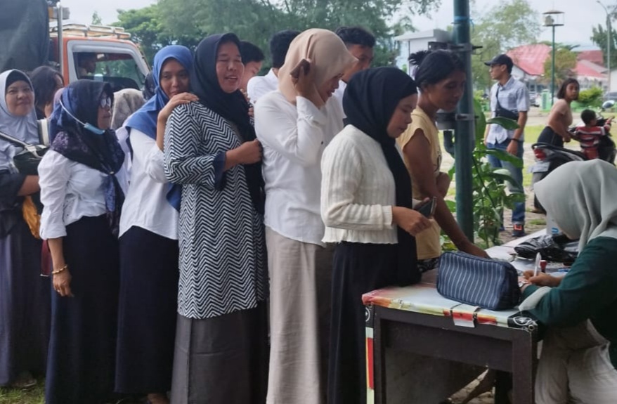 ANTRI OP BERAS: Beberapa masyarakat antri untuk mengikuti operasi pasar di Lapangan Tanjung, kemarin (13/3).(NURUL/LOMBOK POST)