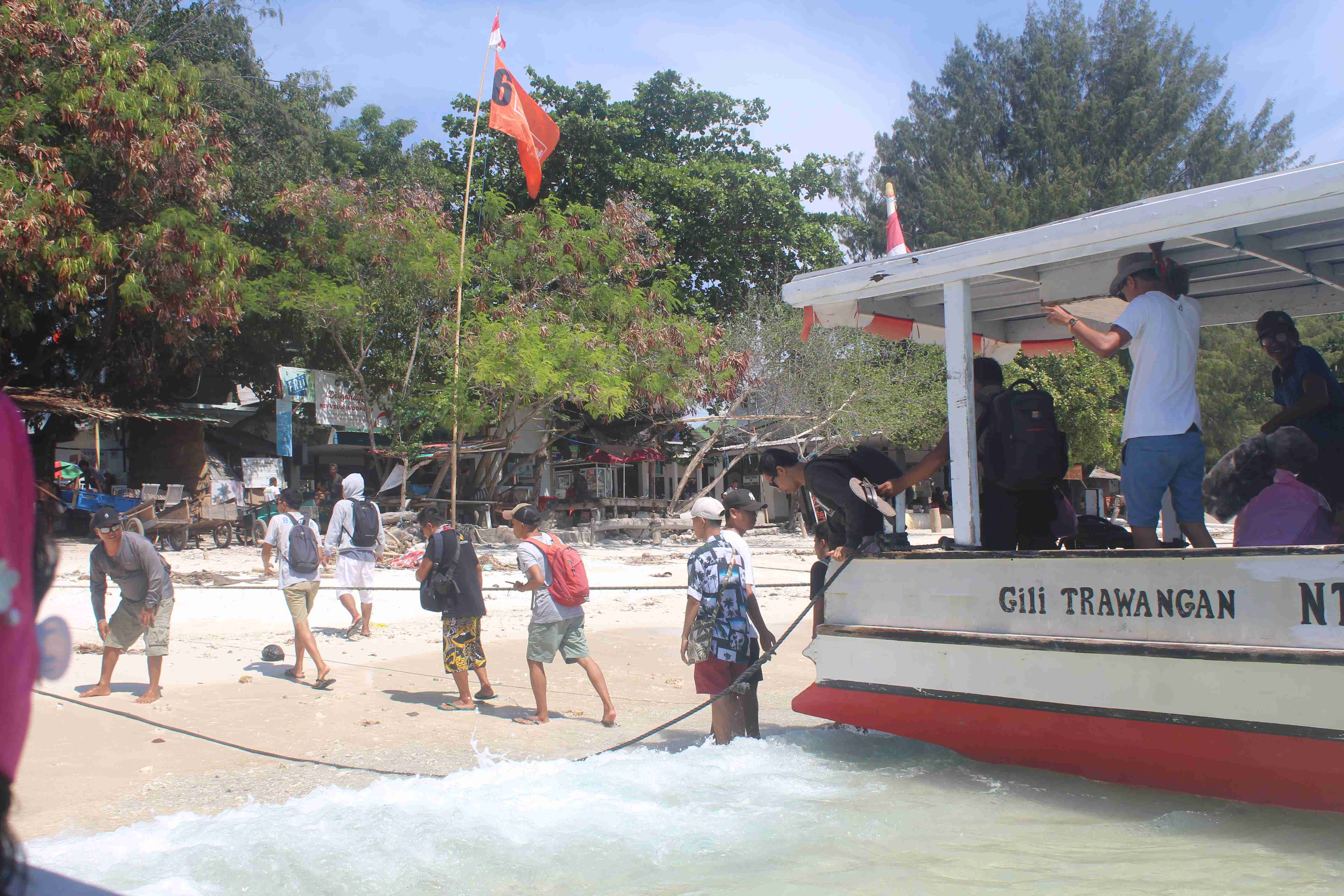 MENIKMATI AKHIR PEKAN: Para wisatawan lokal dan mancanegara secara tertib turun dari boat, setelah menyebrang dari Pelabuhan Bangsal ke Gili Trawangan, untuk menikmati liburan akhir pekan.