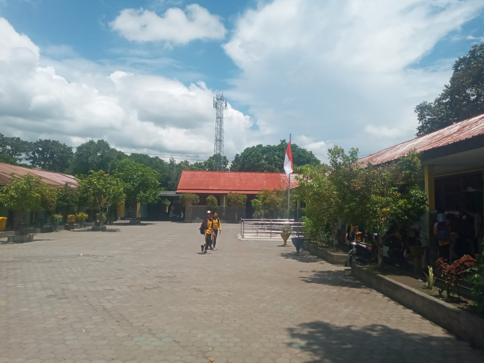 PULANG SEKOLAH: Dua murid SDN 26 Cakranegara berjalan di halaman sekolah setempat, belum lama ini.(ROJAI/LOMBOK POST)