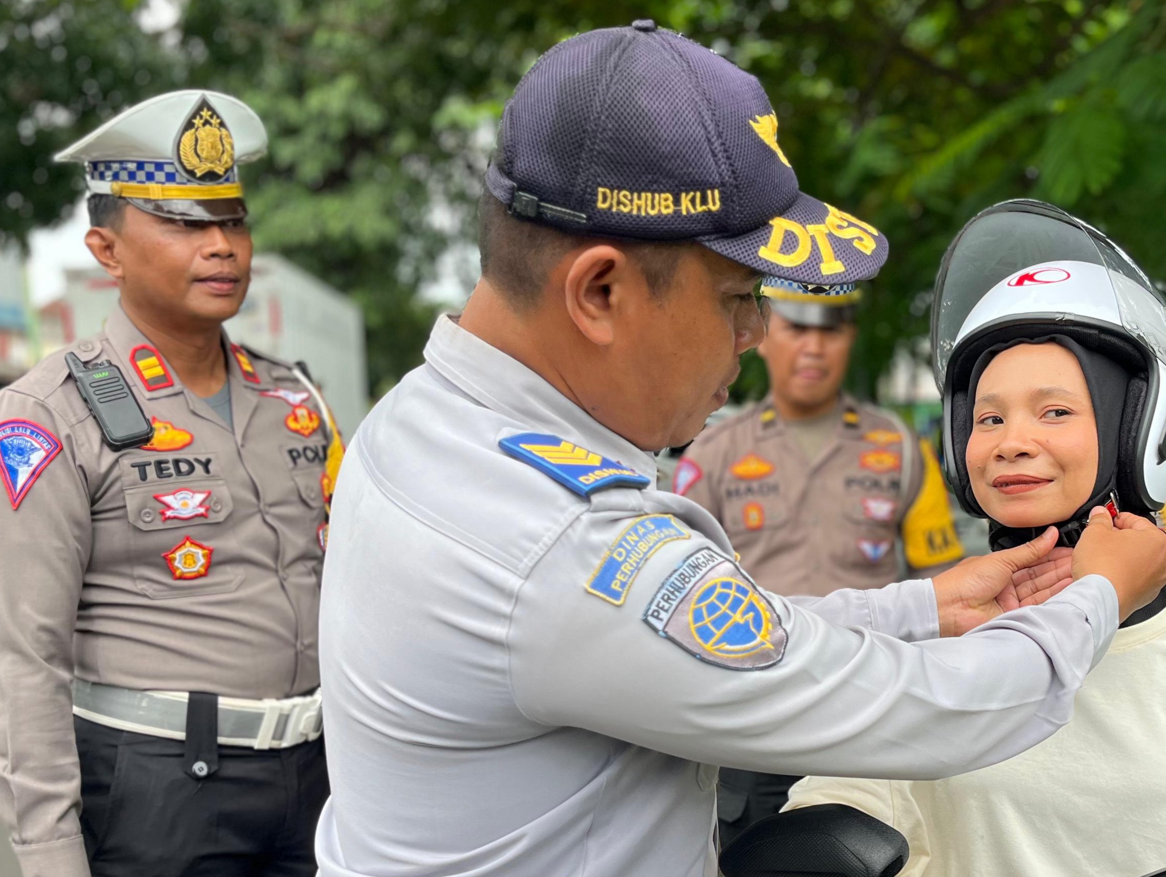 TIM GABUNGAN: Tim Gabungan saat memberikan helm kepada masyarakat yang lewat di Samsat Tanjung, beberapa hari lalu.(NURUL/LOMBOK POST)