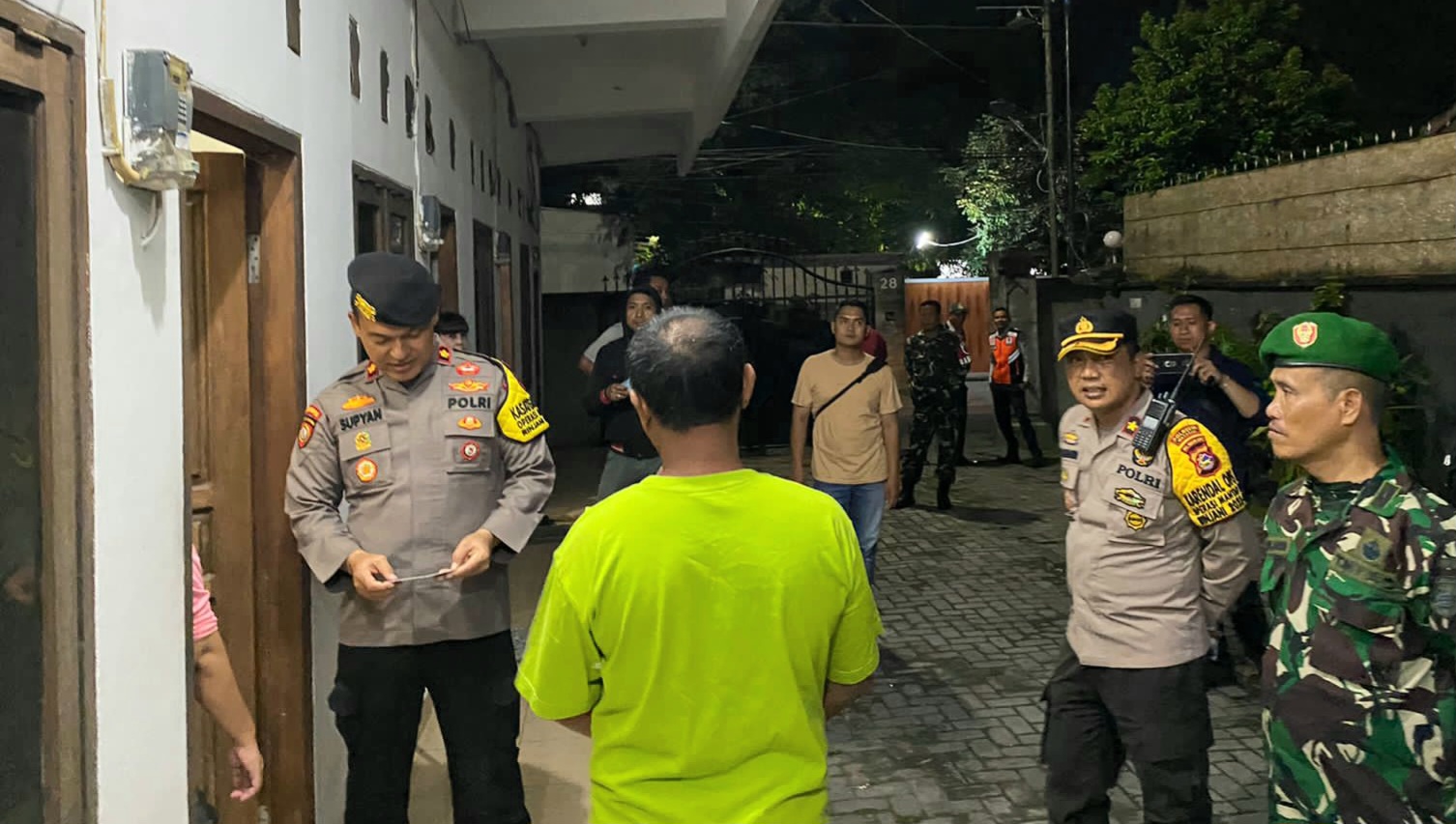 Petugas gabungan Polri dan TNI mengecek identitas penghuni kos-kosan saat melakukan melakukan razia, Sabtu malam (16/3).
