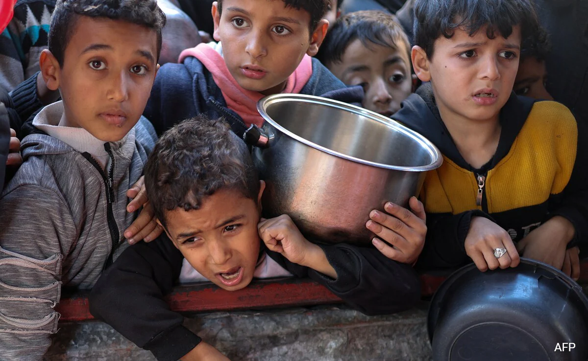 Anak-anak Palestina menunggu untuk menerima makanan yang dimasak oleh dapur amal di tengah kekurangan pasokan makanan. (foto: AFP)