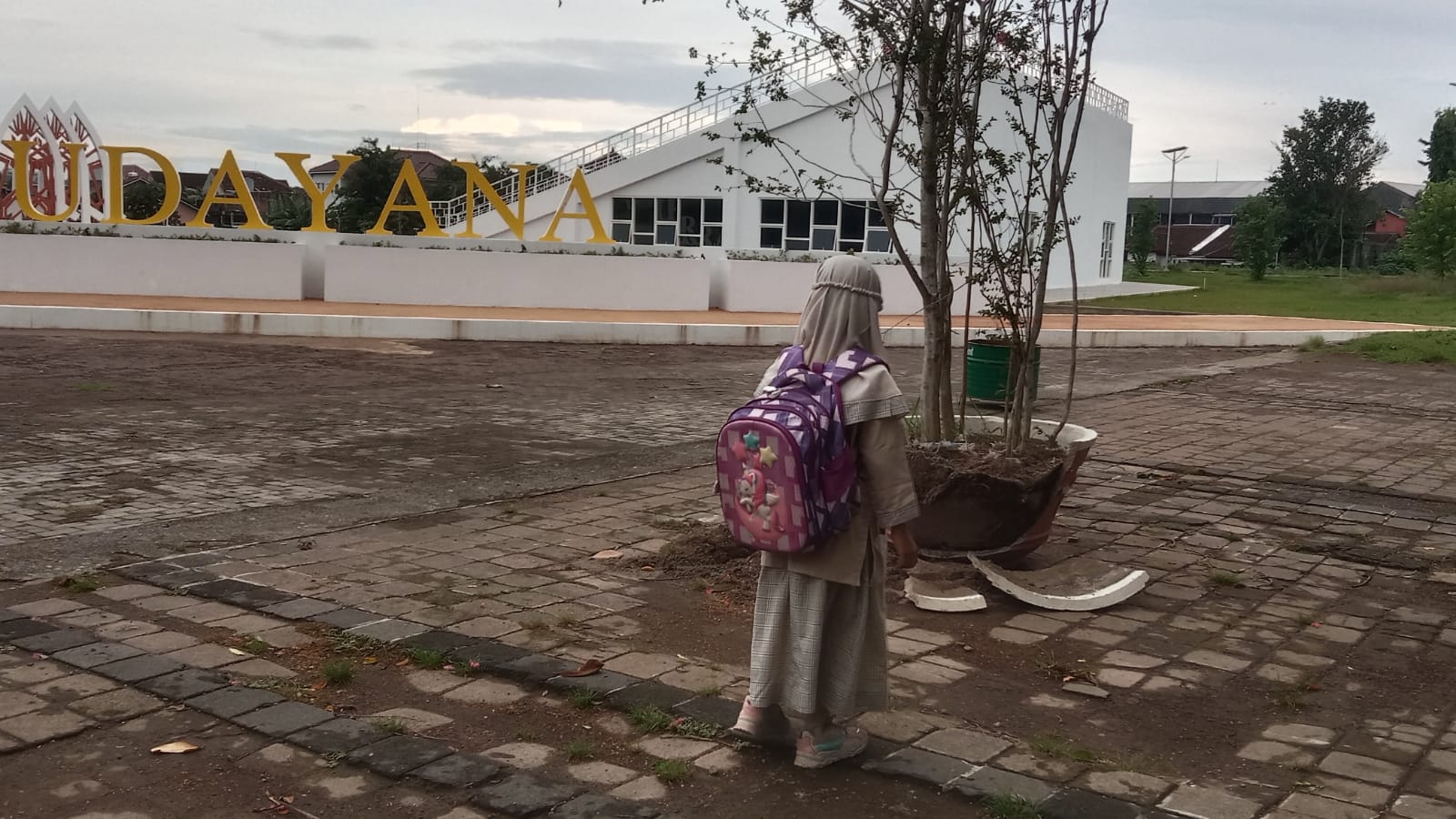 Seorang anak berjalan di depan pot yang pecah akibat dari aksi vandalisme oknum warga, Rabu (20/3).