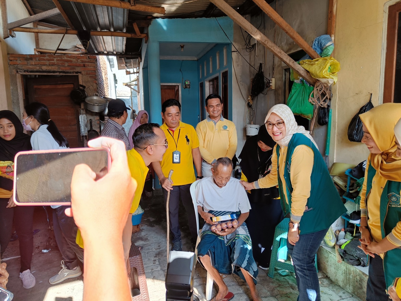 BERMANFAAT: Ketua TP PKK kota Mataram Hj Kinnastri Mohan Roliskana bersama Kepala Dikes Kota Mataram dr Emirald Isfihan memberikan makanan bergizi pada kakek Abdurrahim, Jumat (22/3).