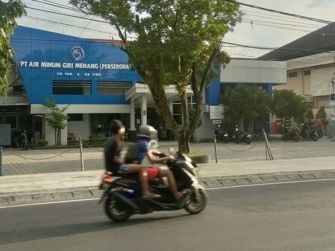 HARUS TAAT HUKUM: Pengendara melintas di depan kantor PT AMGM. BPK telah selesai mengaudit Perusda milik Pemkot Mataram dan Pemkab Lobar.