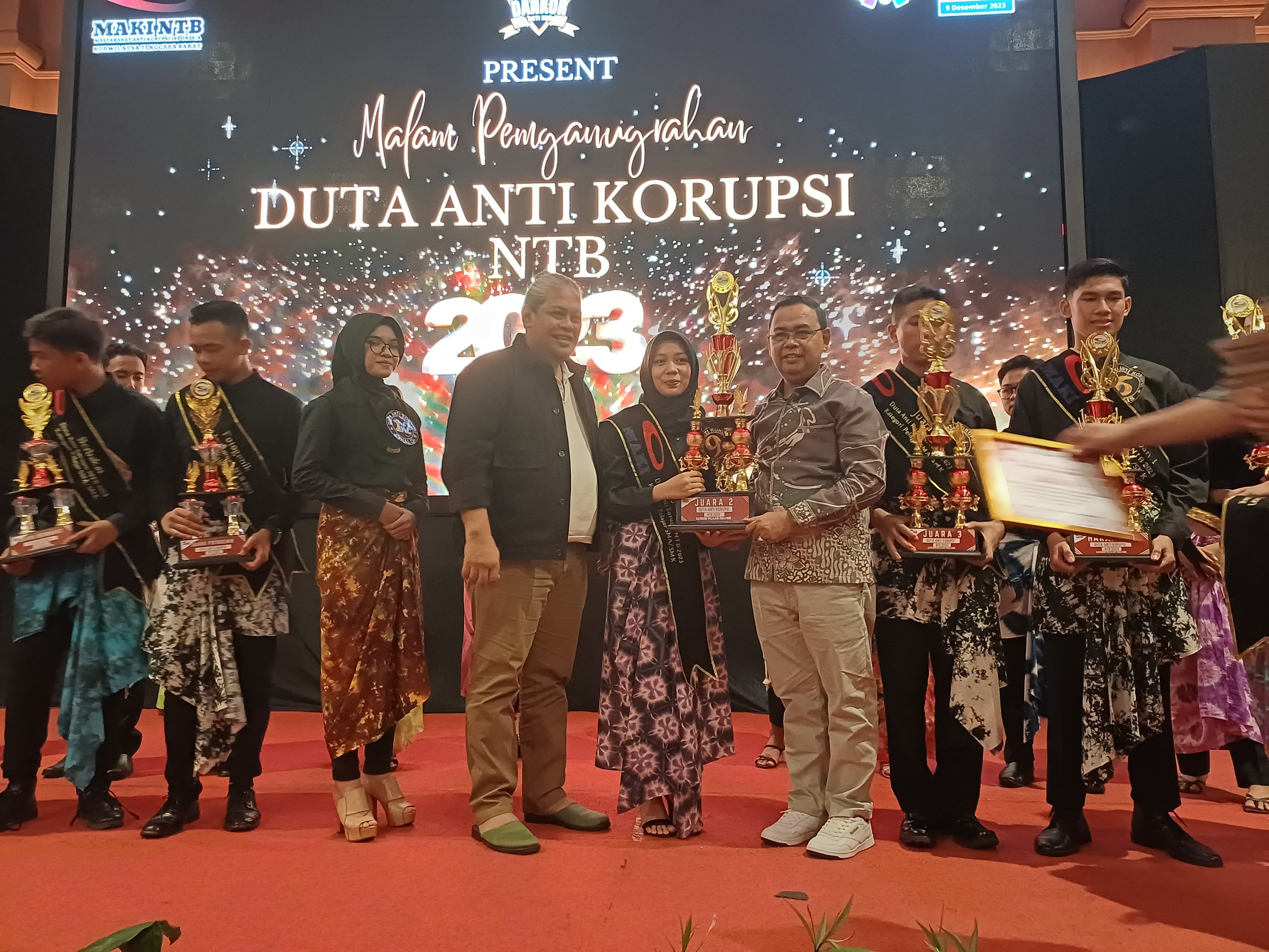 DUTA ANTI KORUPSI: Kepala Dikbud NTB H Aidy Furqan menyerahkan piala kepada siswi SMAN 3 Mataram yang meraih juara II Duta Pelajar Anti Korupsi pada malam penganugerahan di salah satu hotel.
