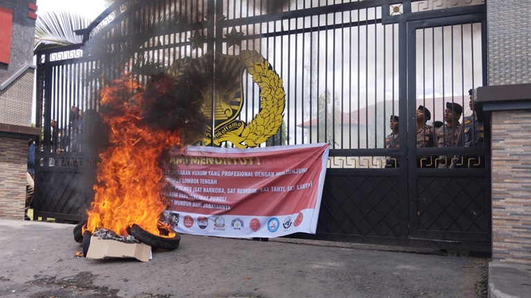 AKSI DEMO: Tumpukan ban bekas dibakar massa di depan Mapolres Loteng,&nbsp;Senin (1/4). Mereka menuntut usut tuntas pungli yang diduga terjadi di dalam unit Polres Loteng. (FOTO: DEWI/LOMBOK POST)  &nbsp;
