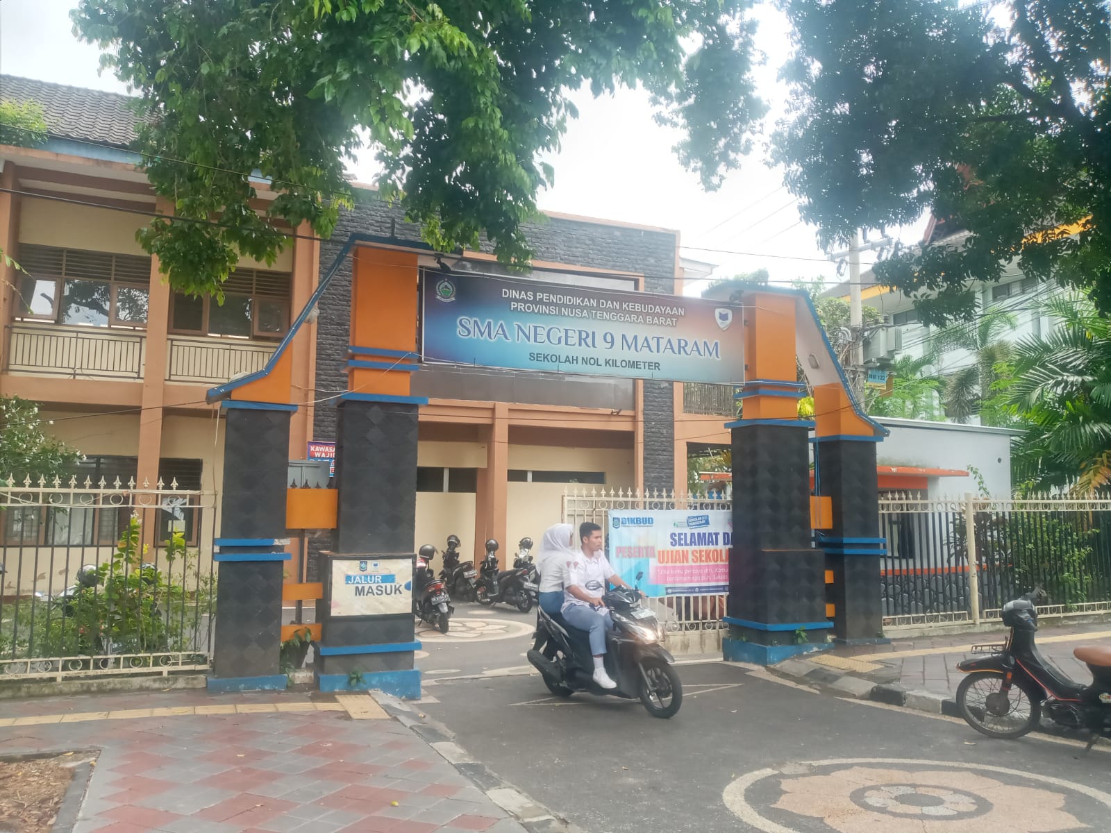 RINDANG: Siswa SMAN 9 Mataram mengenakan sepeda motor di depan sekolah setempat. (ROJAI/LOMBOK POST)