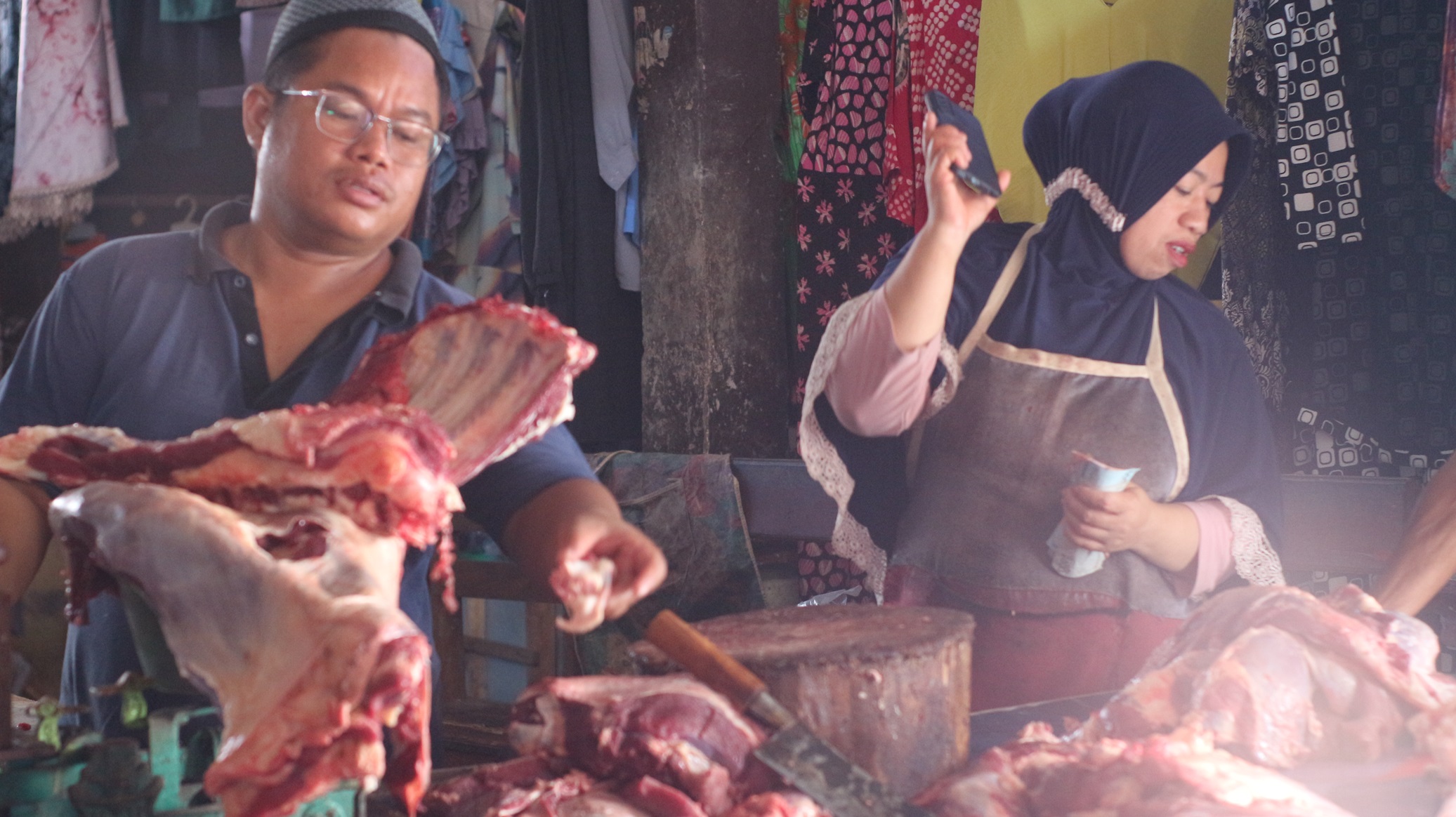 DAGING: Salah satu pedagang daging sapi di pasar Terminal Pancor saat melayani pembeli. (FOTO: SUPARDI/LOMBOK POST)