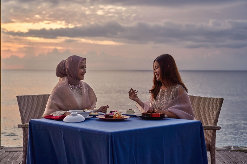 RAMADAN CERIA: Dua pengunjung Holiday Resort Lombok menikmati santapan di pinggir pantai, belum lama ini.