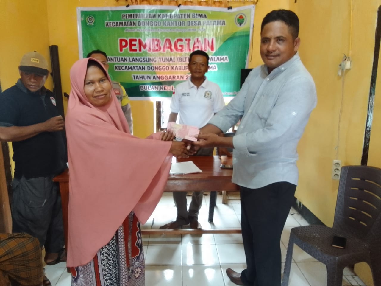 BAGIKAN BLT: Kades Palama, Kecamatan Donggo, Bima Gajali membagikan BLT kepada KPM, pekan lalu. (Istimewa/Lombok Post)