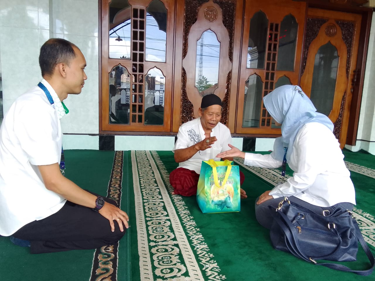 SERAHKAN BANTUAN: Pimpinan PT Pegadaian (Persero) Cabang Gerung Zahroh Wardati memberikan bingkisan ke salah seorang marbot masjid.