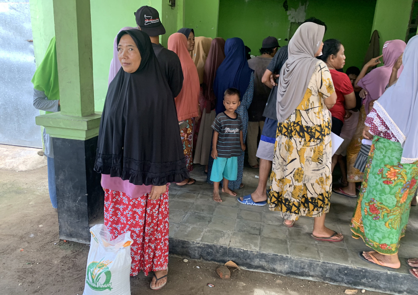 MENERIMA BANTUAN : Seorang ibu menerima bantuan sosial di Desa Kuripan, beberapa waktu lalu.