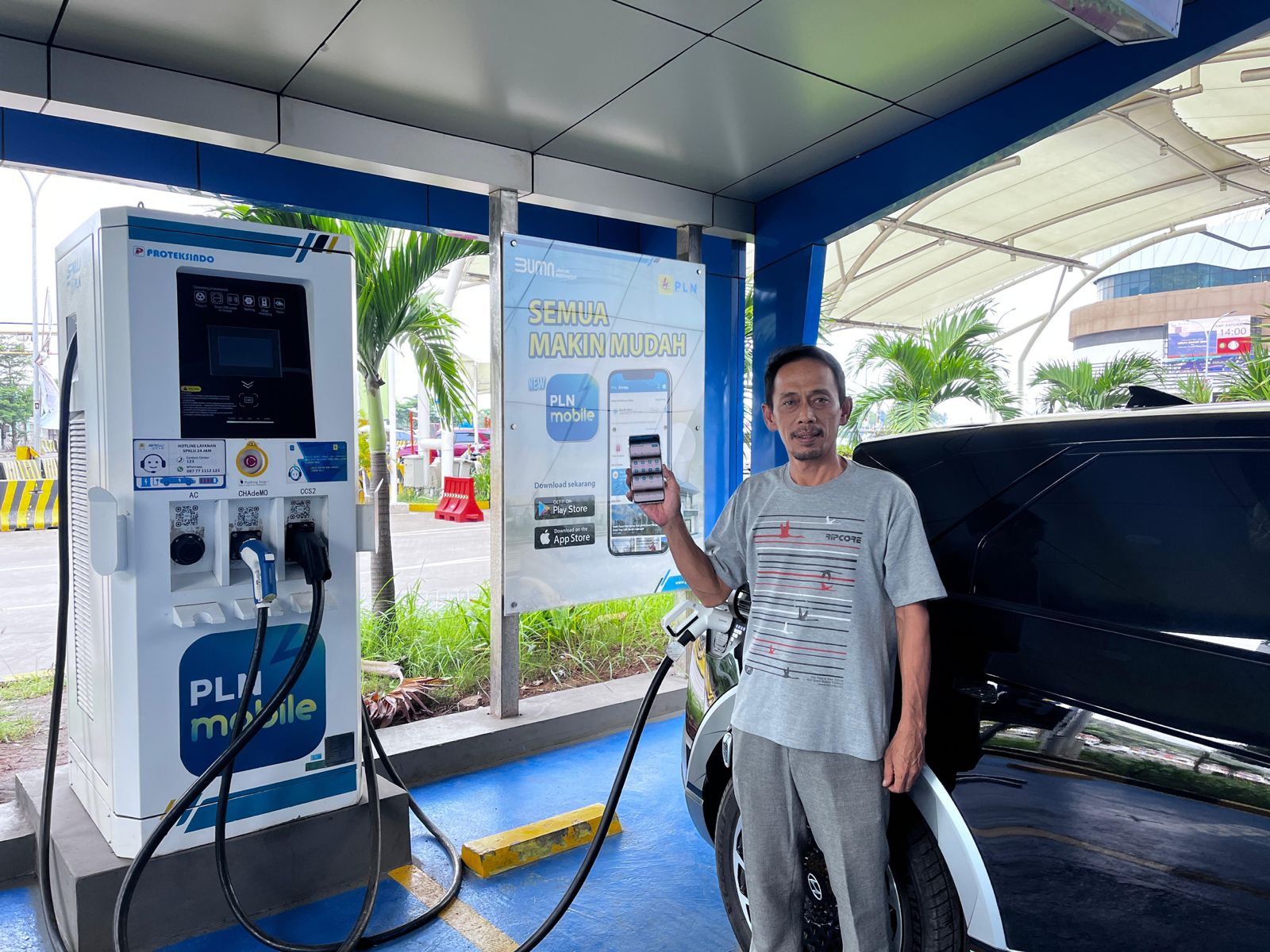 Seorang pengguna mobil listrik melakukan pengisian daya di salah satu SPKLU yang disediakan PLN.