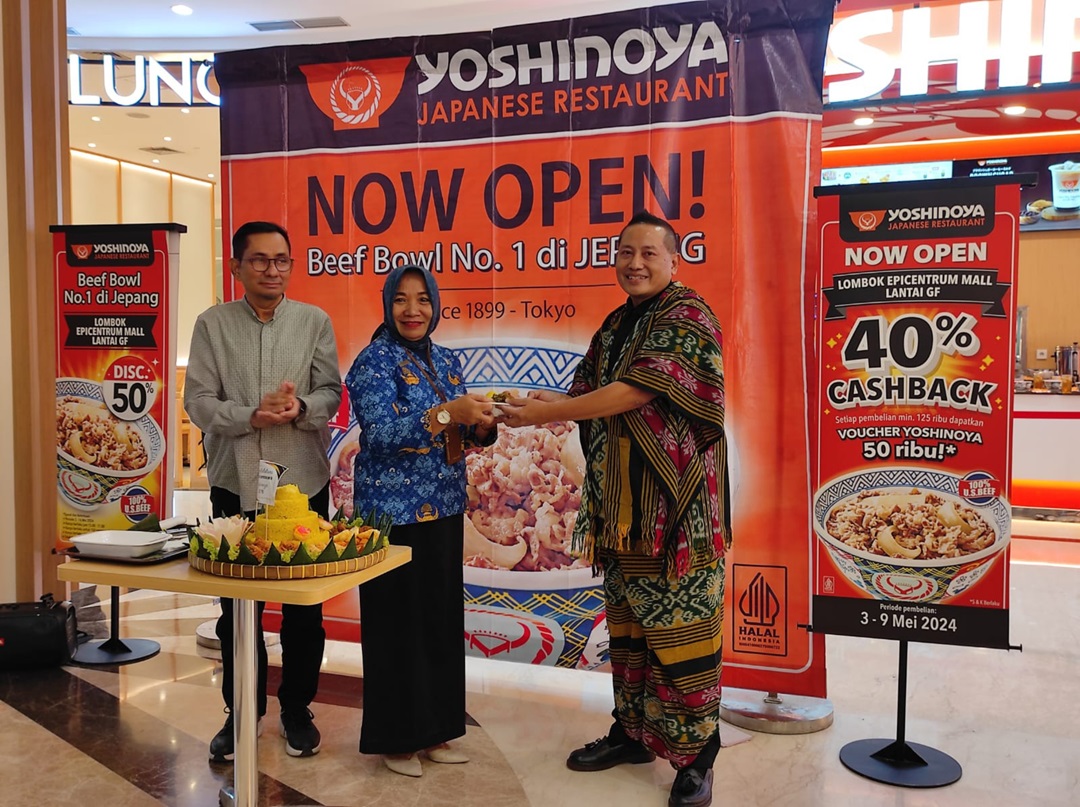 Senior Marketing Activation Manager Yoshinoya Zuhdan Kamal (kanan) memberikan potongan tumpeng pada perwakilan Pemkot Mataram, didampingi General Manager LEM Salim Abdad (kiri)