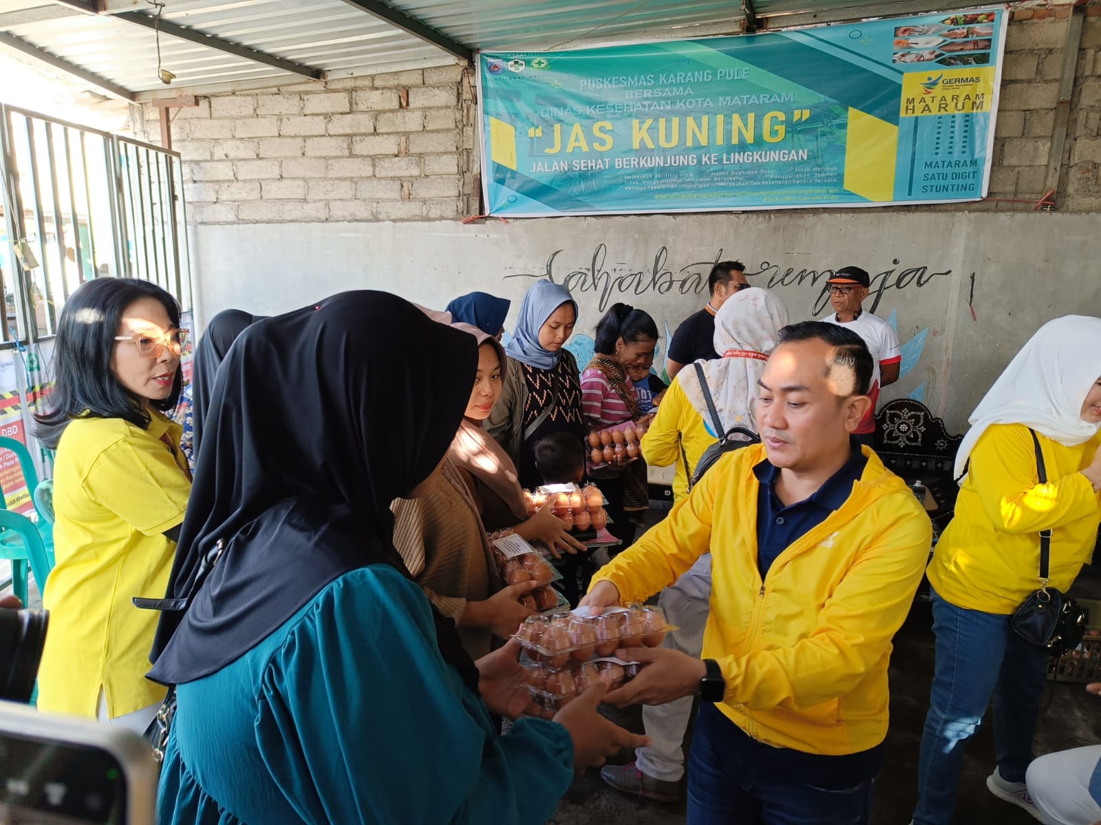 BERGIZI: dr Emirald Isfihan membagikan telur pada ibu-ibu di Lingkungan Jempong Timur.