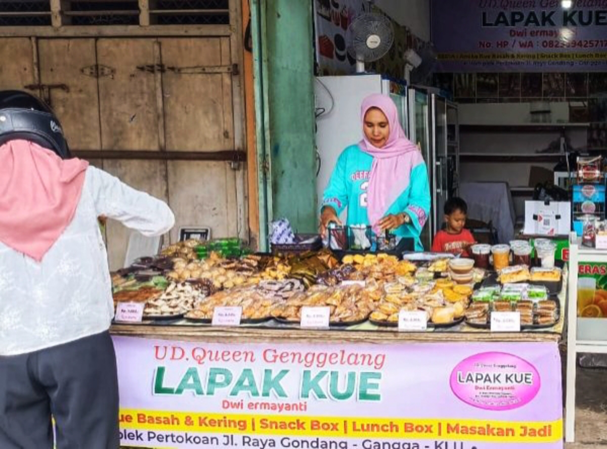LAYANI PEMBELI: Owner UD Queen Genggelang Dwi Ermayanti (kanan) melayani pembeli kue di tokonya, belum lama ini.