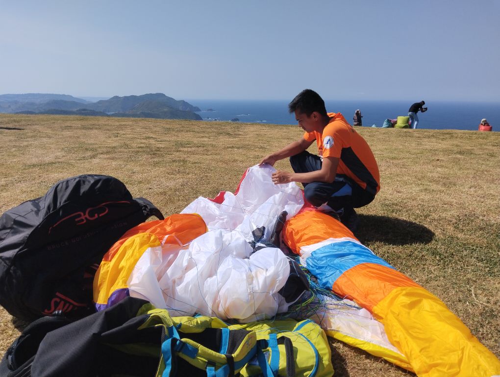 Seorang atlet mempersiapkan perlengkapan terjun payung miliknya pada ajang IPAC 2024 di Sky Lancing, Desa Mekarsari, Praya Barat, Lombok Tengah.