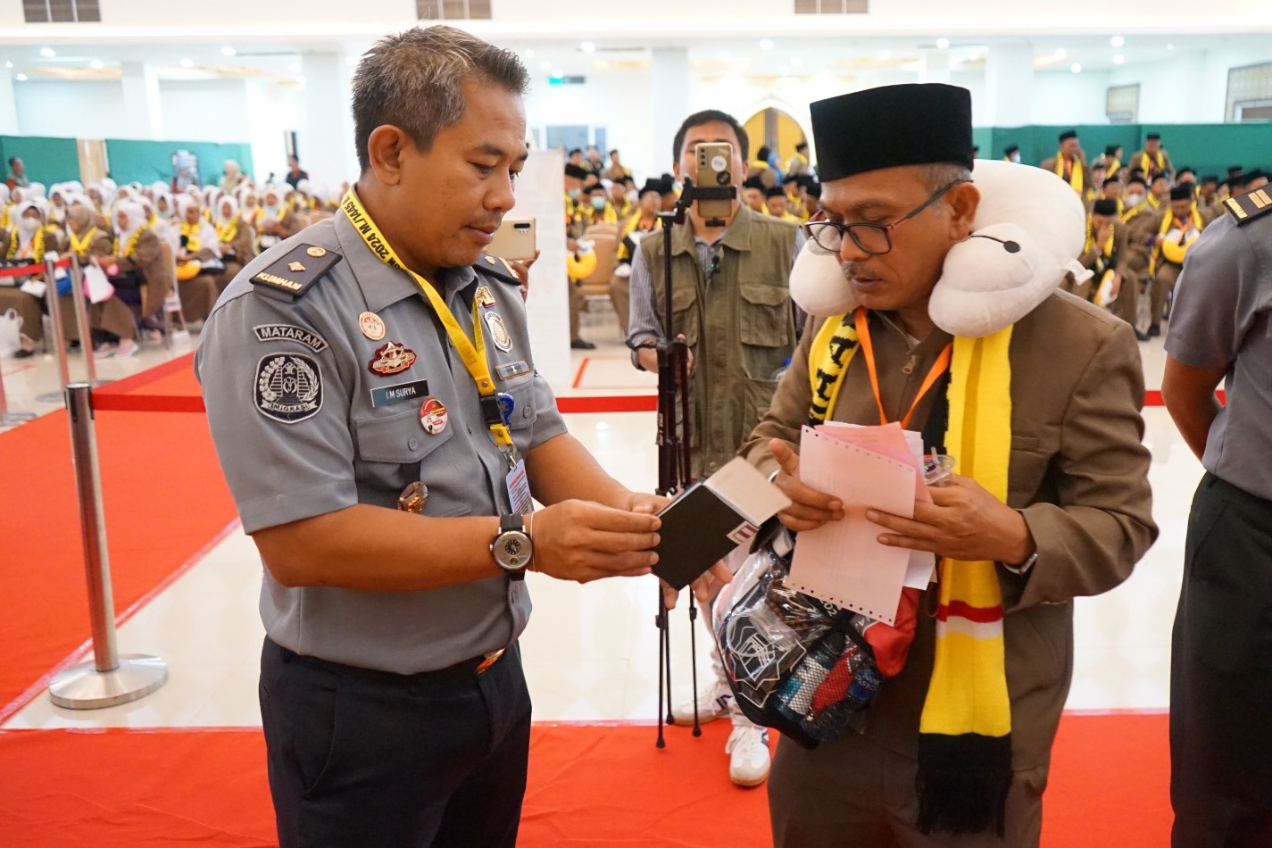 SIMBOLIS: Perwakilan Satuan Tugas Haji Kanwil Kemenkumham NTB menyerahkan dokumen keimigrasian yakni paspor dan visa haji kepada perwakilan jamaan haji Kloter 1 LOP.