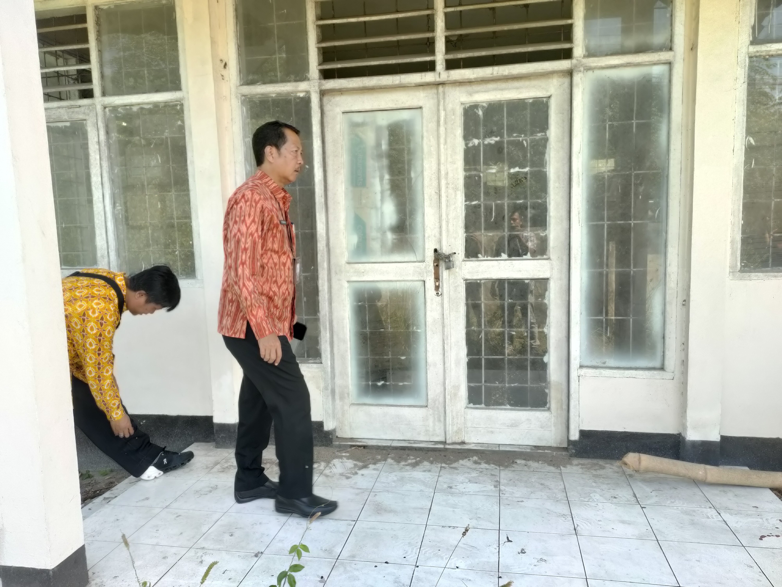 CEK BANGUNAN: Sekda Kota Mataram berjalan di depan gedung Farmasi milik Dinas Kesehatan Kota Mataram saat mengecek kondisi aset di kawasan Pagutan, Mataram, kemarin (17/5). (harli/Lombokpost)