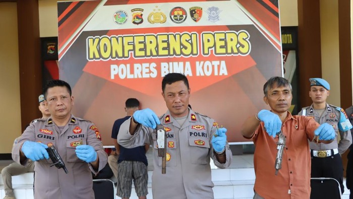 INI PISTOL RAKITANNYA: Wakapolres Bima Kota Kompol Herman (tengah) menunjukan barang bukti senpi rakitan yang diamankan dari tangan DL dan MS, akhir pekan lalu.(POLRES BIMA KOTA FOR LOMBOK POST)