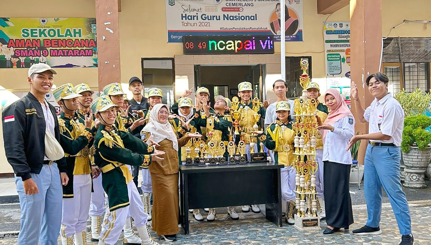 Tim Paskibra SMAN 9 Mataram bersama kepala sekolah dan pembina Paskibra dengan piala yang diraih pada event Garuda Kostum di halaman sekolah setempat, pekan lalu.