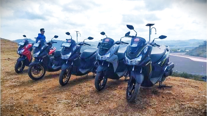 PERJALANAN KIAN SERU: Deretan unit motor Yamaha Lexi LX 155 di atas Bukit Seger, Kuta Mandalika dengan latar Sirkuit Internasional Mandalika, pada Minggu (27/5) lalu.  (Dewi/Lombok Post)