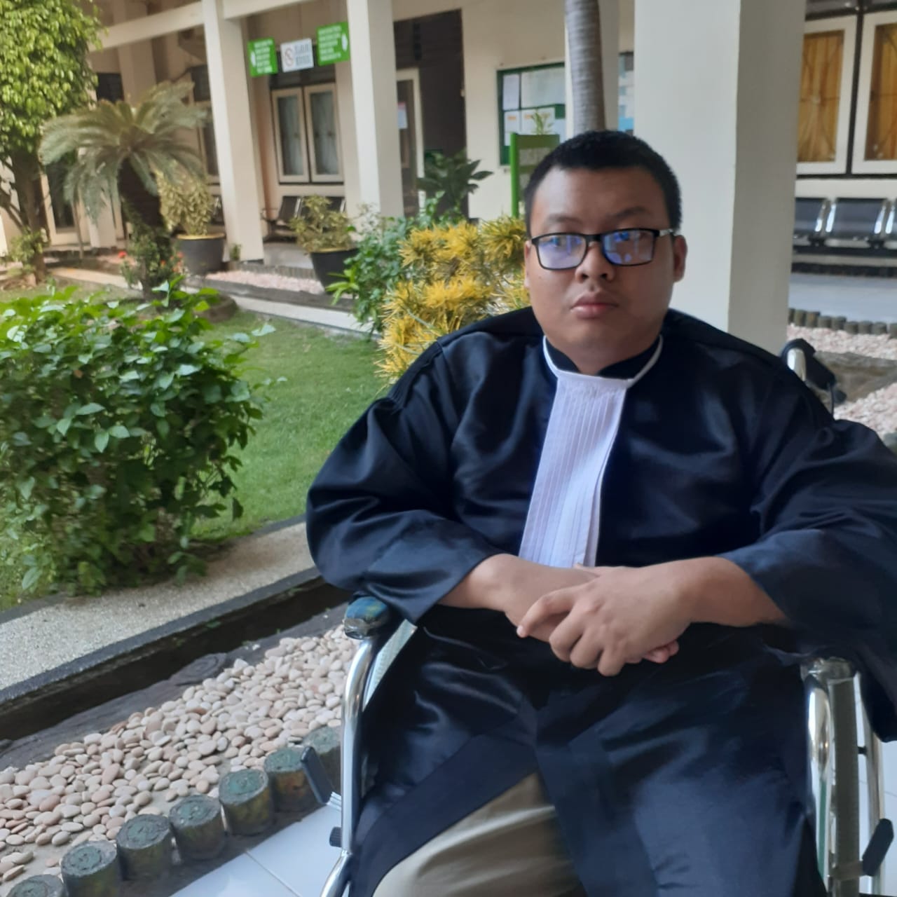 TETAP BERKARYA: Pengacara Indra Pradipta  duduk di kursi roda menggunakan toga saat hendak sidang di Pengadilan Negeri Mataram, Rabu (29/5) lalu.(HARLI/LOMBOK POST)
