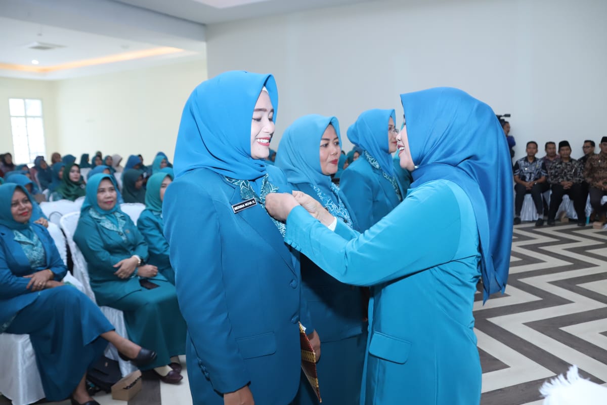 SELAMAT BERTUGAS: Ketua TP PKK Loteng Baiq Nurul Aini Pathul Bahri (kanan) menyematkan lencana kepada tujuh Ketua PKK Kecamatan yang baru dalam pelantikan.(Prokopim for Lombok Post)