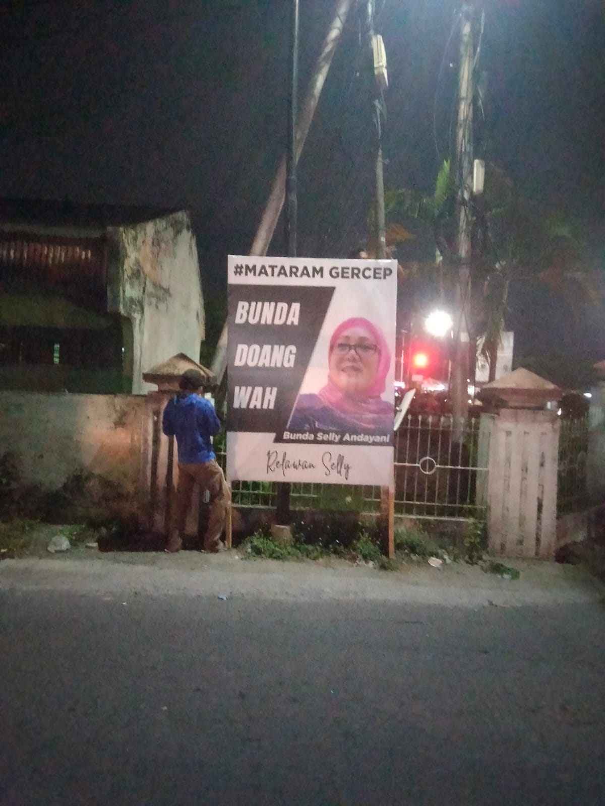 AKSI RELAWAN: Seorang warga memasang baliho Selly Andayani.