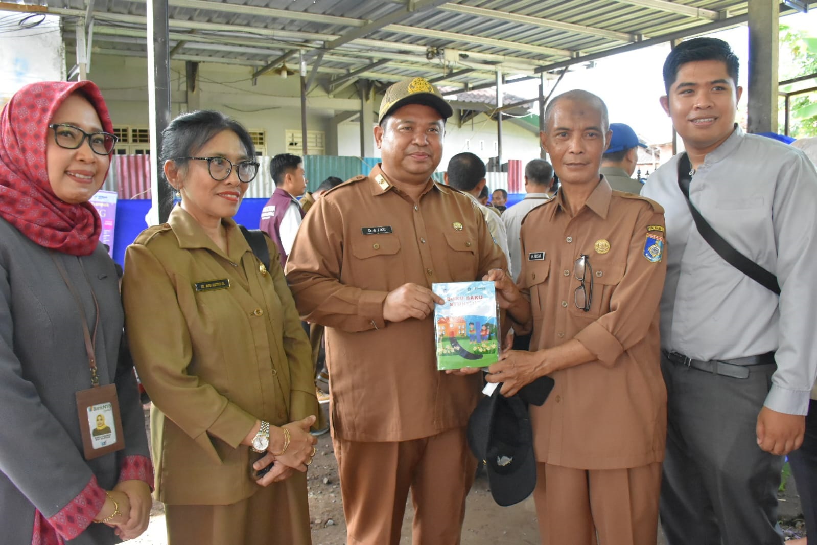 Kepala Dikes NTB H Lalu Hamzi Fikri membagikan buku saku stunting sebagai bahan sosialisasi dan penguatan pelibatan perangkat daerah dalam pencegahan stunting.