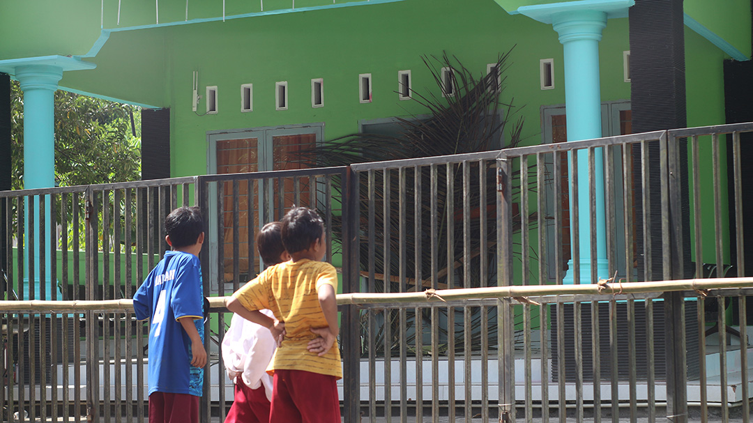 SEGEL: Anak-anak di Desa Nyiur Tebel yang baru pulang sekolah melihat kondisi Kantor Desa Nyiur Tebel yang disegel dan dilempari batu oleh warga.(SUPARDI/LOMBOK POST)