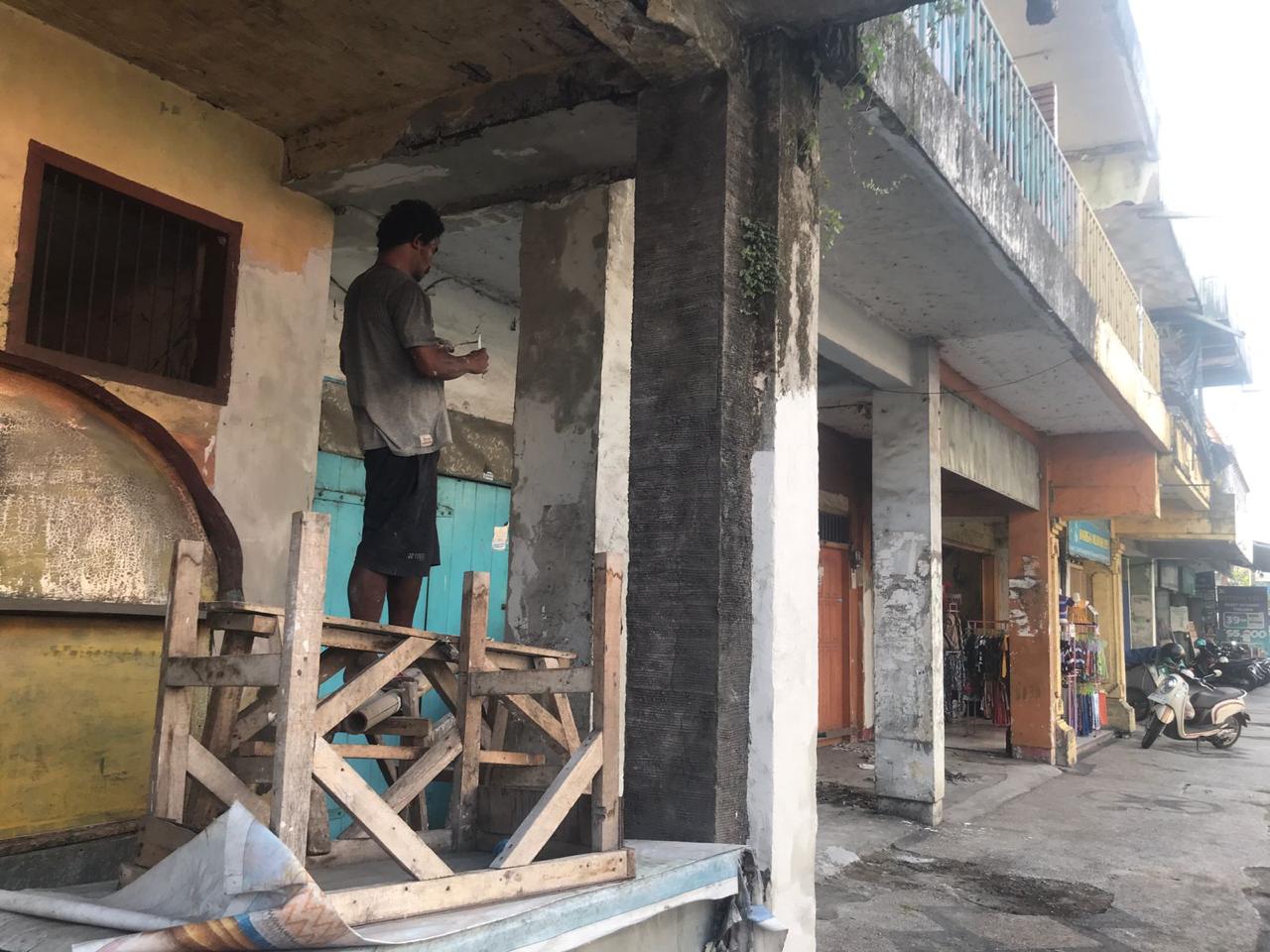 UBAH WARNA: Pekerja tengah mengecat ulang dinding tembok bangunan tua di kawasan Kota Tua Ampenan. (ZAD/LOMBOK POST)