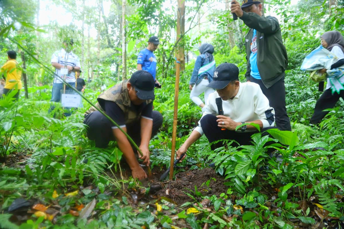 TARGET 10 BESAR: Bupati Loteng Lalu Pathul Bahri beserta jajaran menanam pohon di kawasan Tibu Nangklok, Desa Aik Berik, Kecamatan Batukliang Utara, Loteng, Jumat (7/6).  (Dewi/Lombok Post)