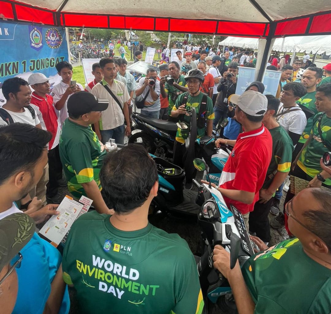 AMBIL BAGIAN: Kepala SMKN 3 Mataram Sulman Haris (pakai helm) menjelaskan terakit konversi  sepeda motor BBM menjadi listrik pada Hari Lingkungan Sedunia di Pantai Loang Baloq.(SMEKTI FOR LOMBOK POST)