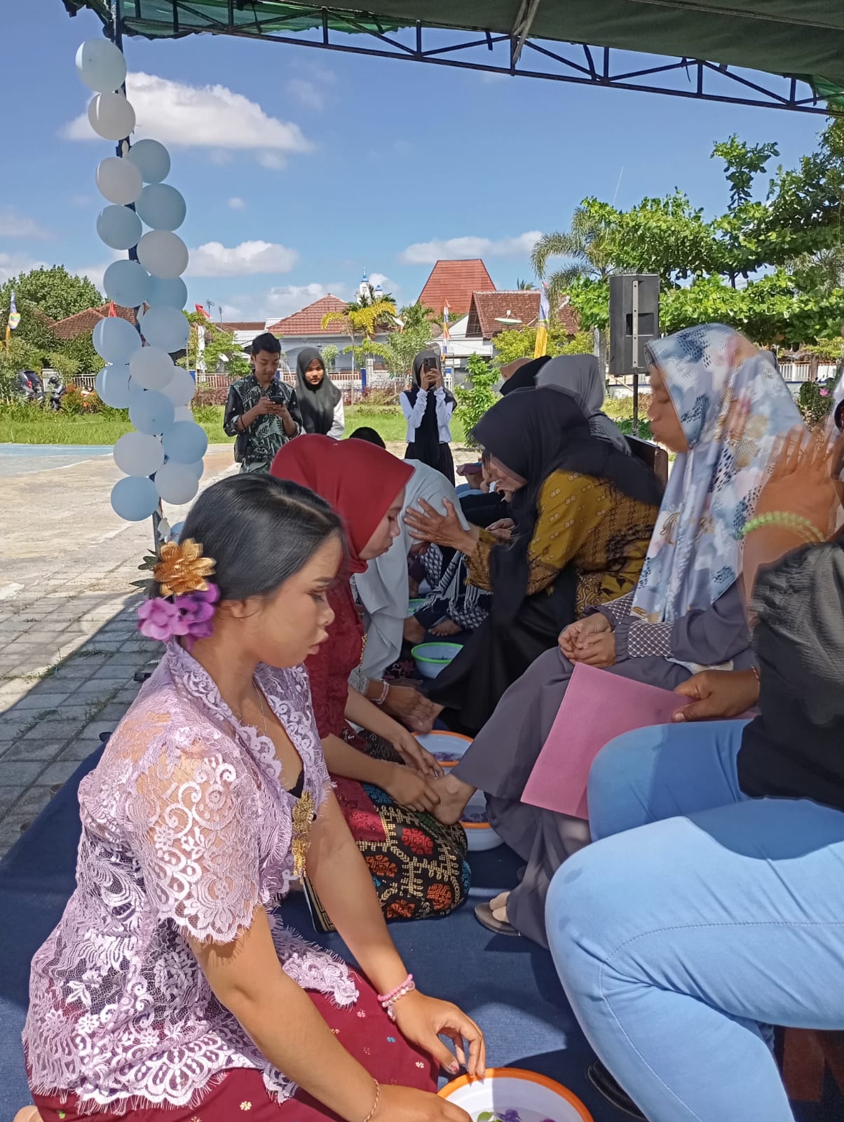 TRADISI: Siswa berprestasi SMPN 23 Mataram cuci kaki orang tuanya pada acara pelepasan di sekolah setempat, kemarin (10/6).(ROJAI/LOMBOK POST)