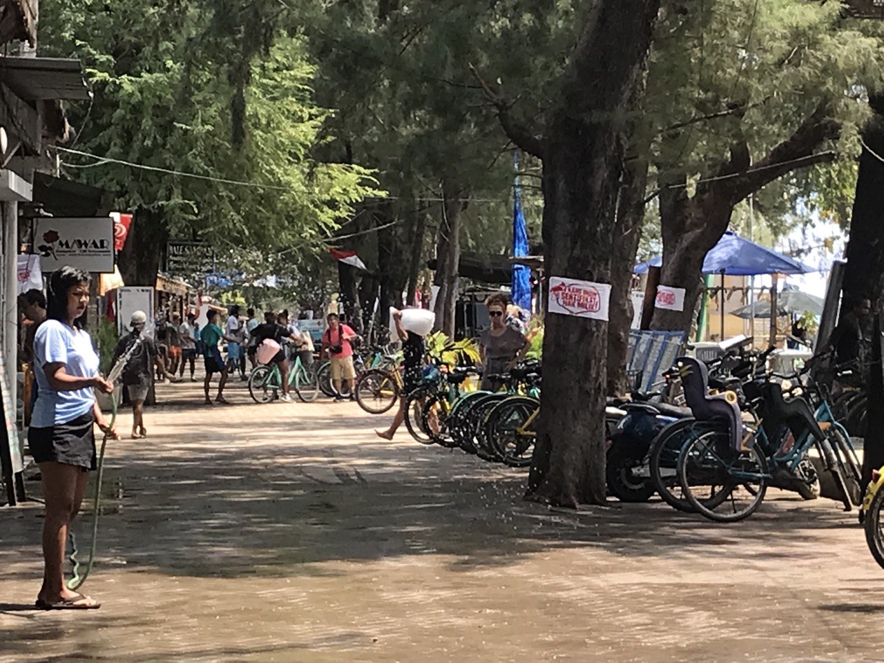 MENYIRAM: Seorang pekerja sedang menyiram halaman resto yang ada di Gili Trawangan, beberapa waktu lalu.(NURUL/LOMBOK POST)