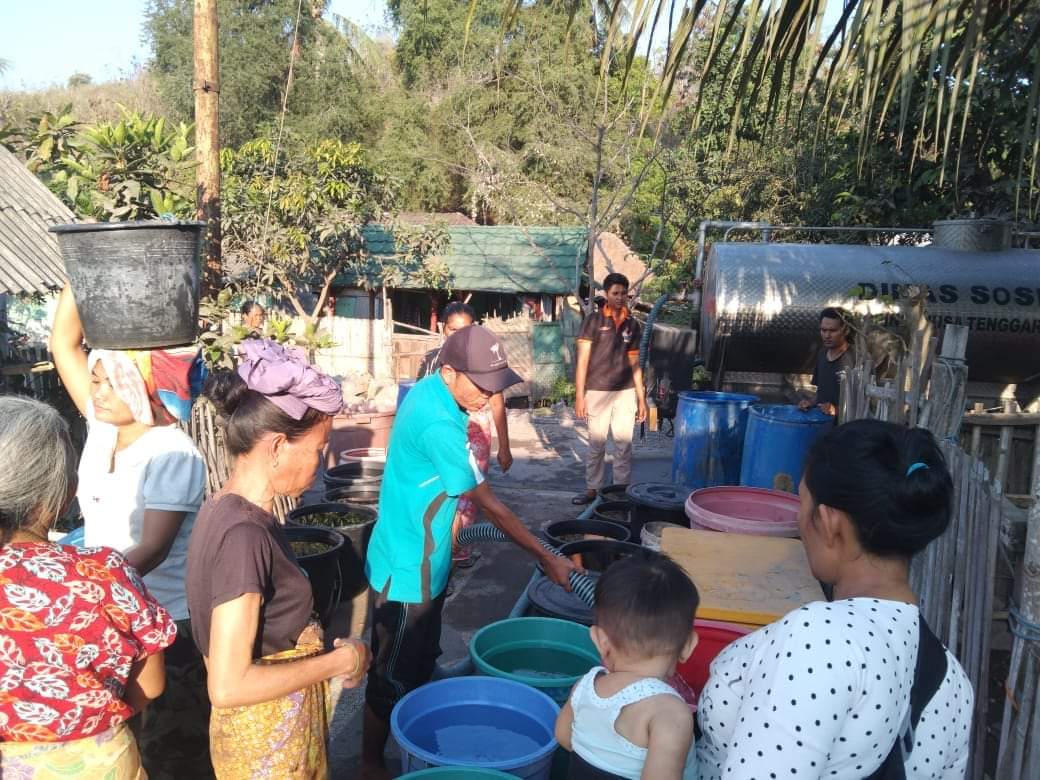 GERAK CEPAT: Petugas TAGANA Dinsos NTB (baju biru) mendistribusikan kebutuhan air bersih kepada warga, di salah satu wilayah terdampak kekeringan di Bumi Gora.(DOK/LOMBOK POST)