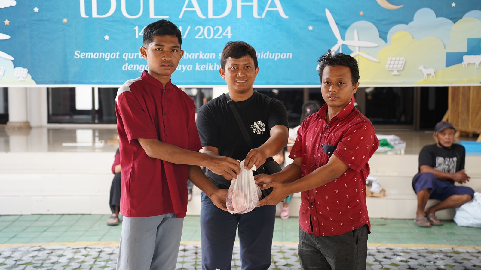 Penyaluran daging hewan kurban dari PLN UIP Nusra secara simbolis kepada salah satu penerima.