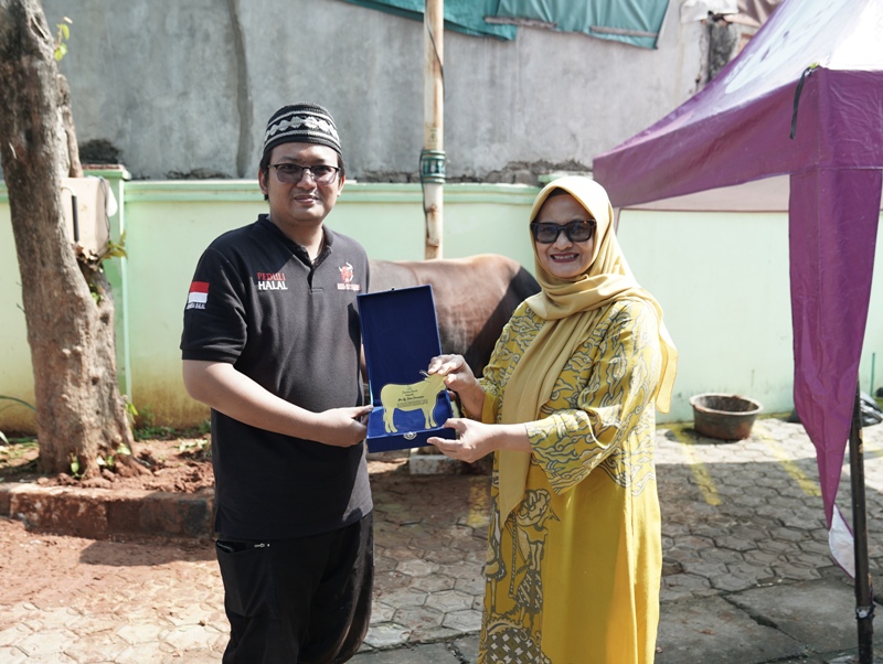 Presdir & CEO XL Axiata Dian Siswarini (kanan) menyerahkan hewan kurban miliknya kepada Ketua DKM Musala An-Nur Syafa