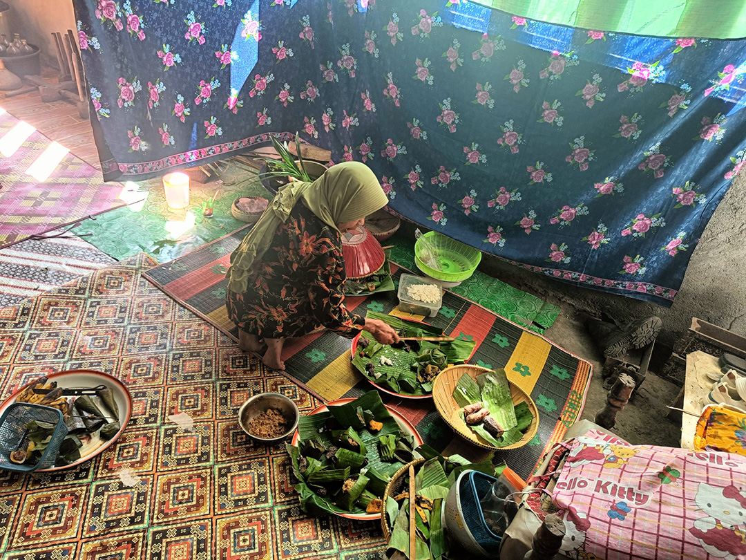 BERBAGI: Niniq Apuk tengah merapikan apah andang prosesi pembuatan Lempot Umbaq, Minggu (23/6). (ZAD/LOMBOK POST)