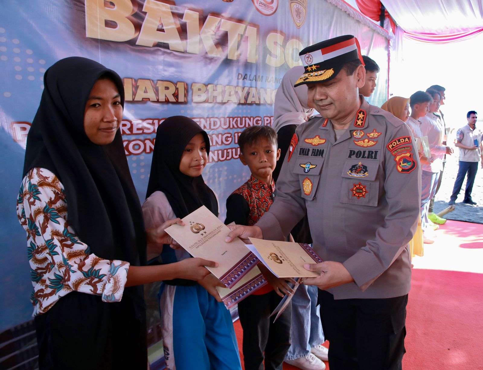 Kapolda NTB Irjen Umar Faroq menyerahkan beasiswa dalam rangkaian peringatan Hari Bhayangkara ke-78 di Desa Kuranji, Kecamatan Labuapi, Lombok Barat, Kamis (27/6).