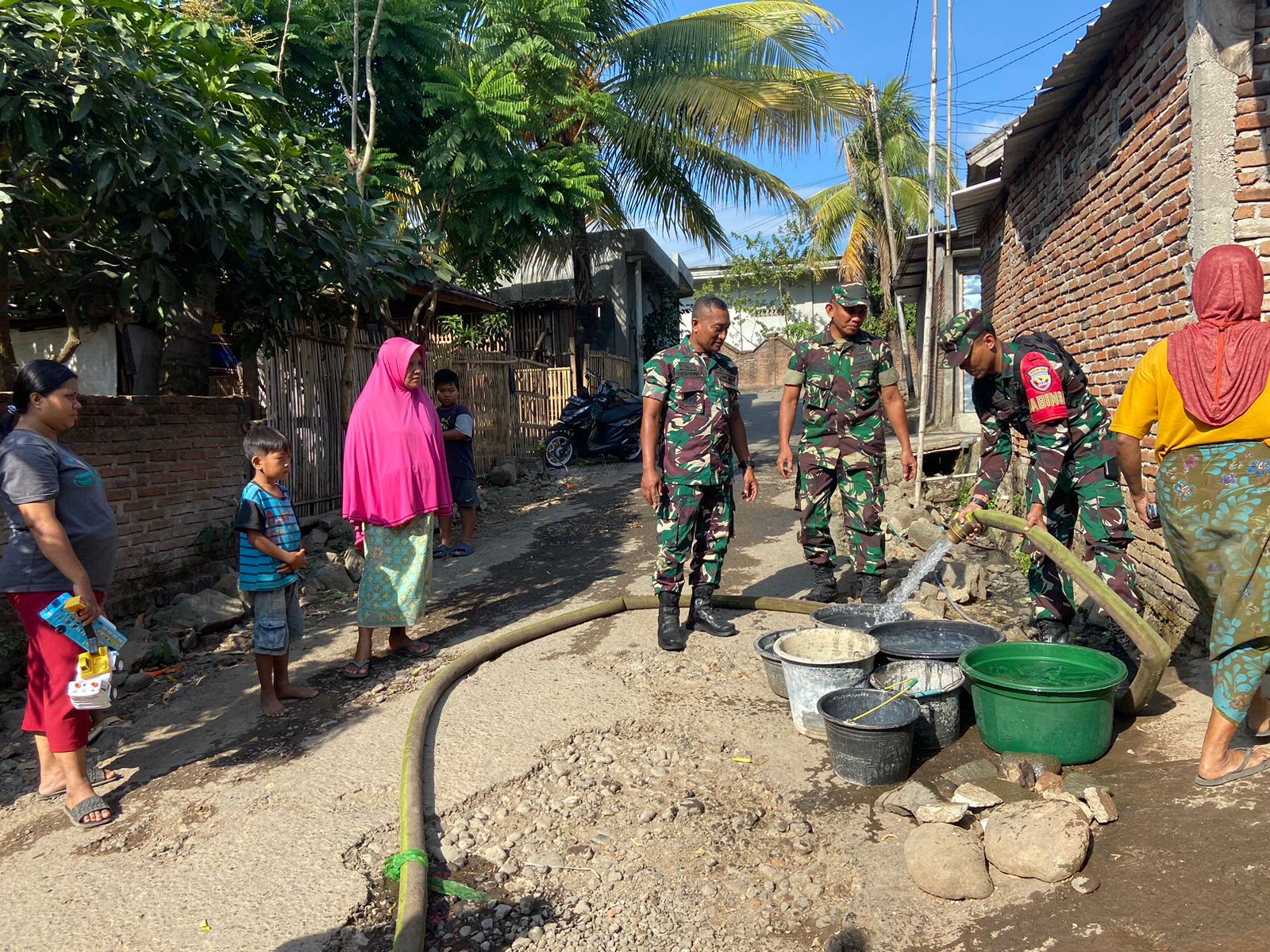 PENYALURAN AIR: Masyarakat Kuripan Selatan menerima penyaluran air dari Koramil 1606-04/Gerung bersama Dinas Pemadam Kebakaran Lombok Barat, beberapa waktu lalu. (IST/LOMBOK POST)