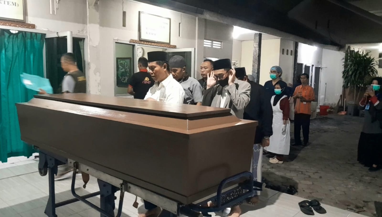 SALAT JENAZAH: Sejumlah pengurus Ponpes Al-Aziziyah Kapek Gunungsari melakukan salat jenazah di depan ruang autopsi RS Bhayangkara Mataram, Sabtu malam (29/6). (TONI/LOMBK POST)
