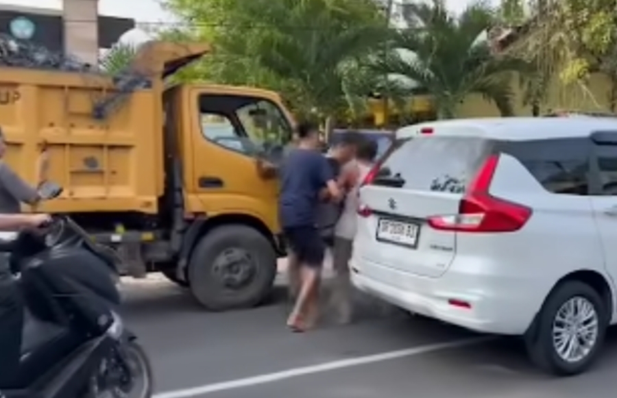 DIBOPONG: Seorang sopir truk sampah Dinas LH Kota Mataram saat diangkat rekannya karena tiba-tiba lemas.  (IVAN/LOMBOK POST)