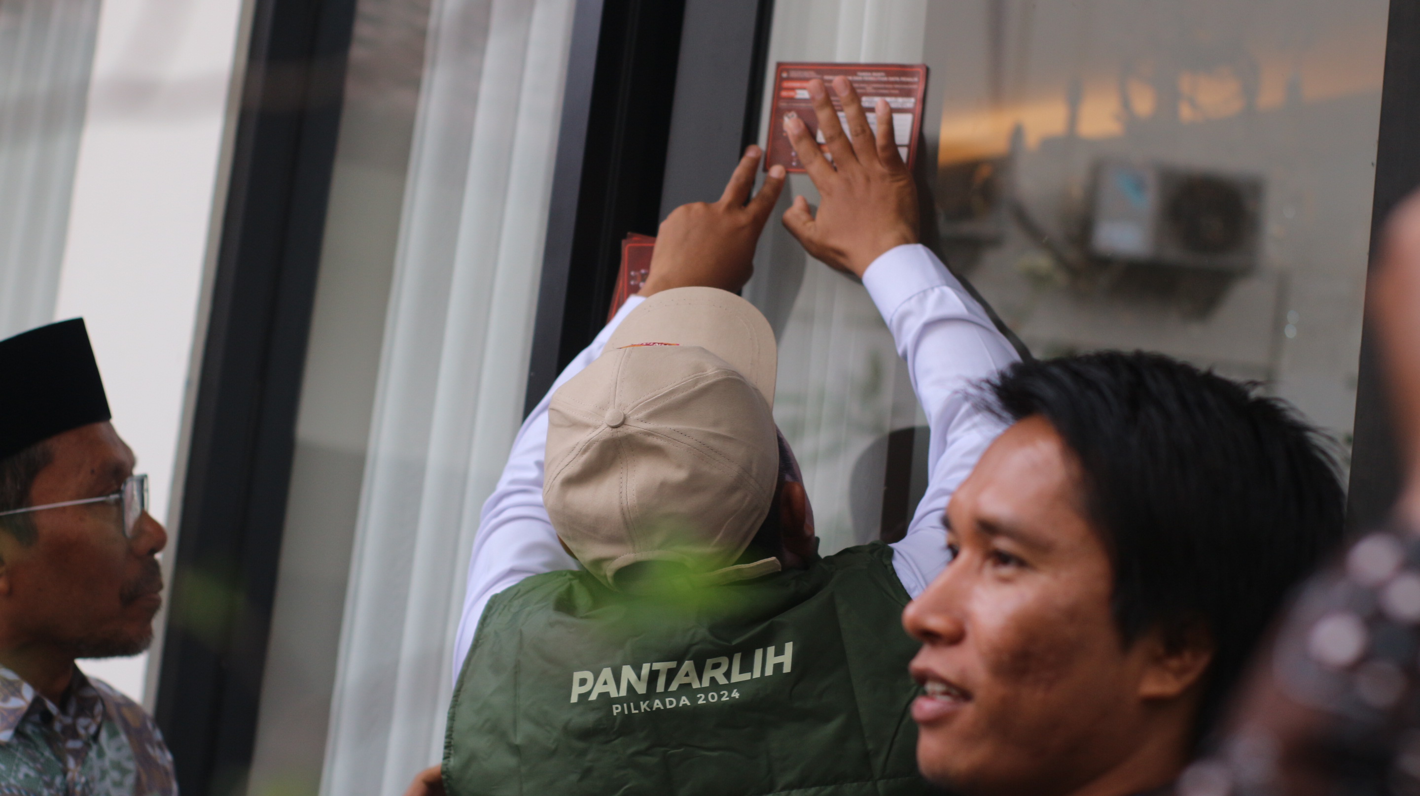 COKLIT: Petugas Pemuktahiran data Pemilih (Pantarlih) saat menempel stiker bukti pencermatan dan penelitian data pemilih (Coklit) . (SUPARDI/LOMBOK POST)