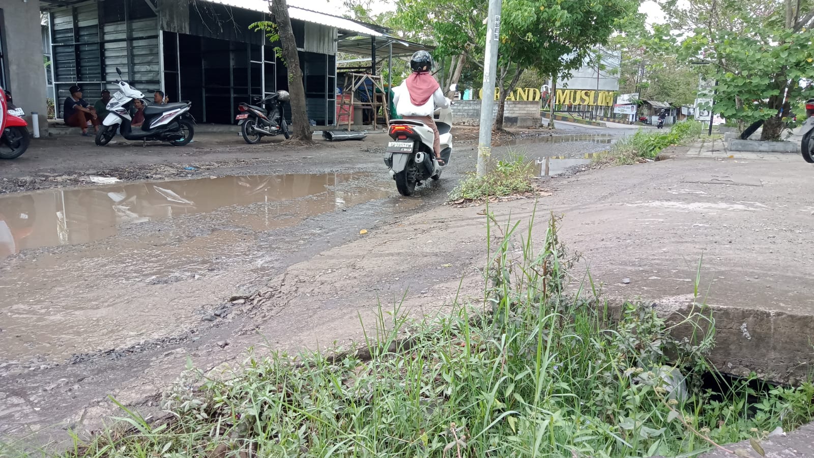 GENANGAN AIR: Seorang pengendara melintasi jalan terong tawah yang rusak dan berlubang beberapa waktu lalu. (CHIA/LOMBOK POST)