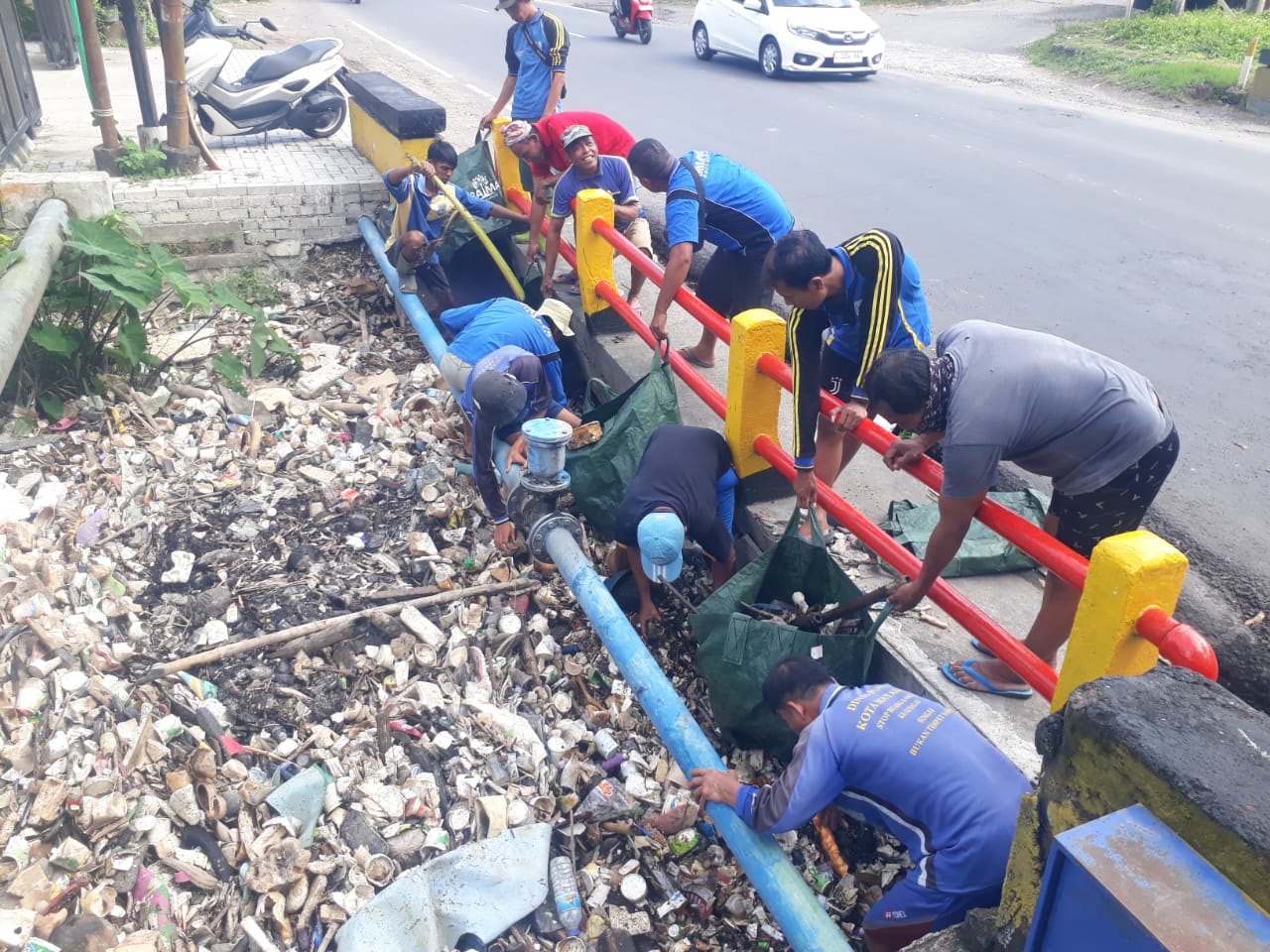 BUTUH KESADARAN MASYARAKAT: Sejumlah petugas Dinas PUPR Kota Mataram mengangkut sampah sungai yang menumpuk di atas saluran, akhir pekan lalu. (HARLI/LOMBOK POST)